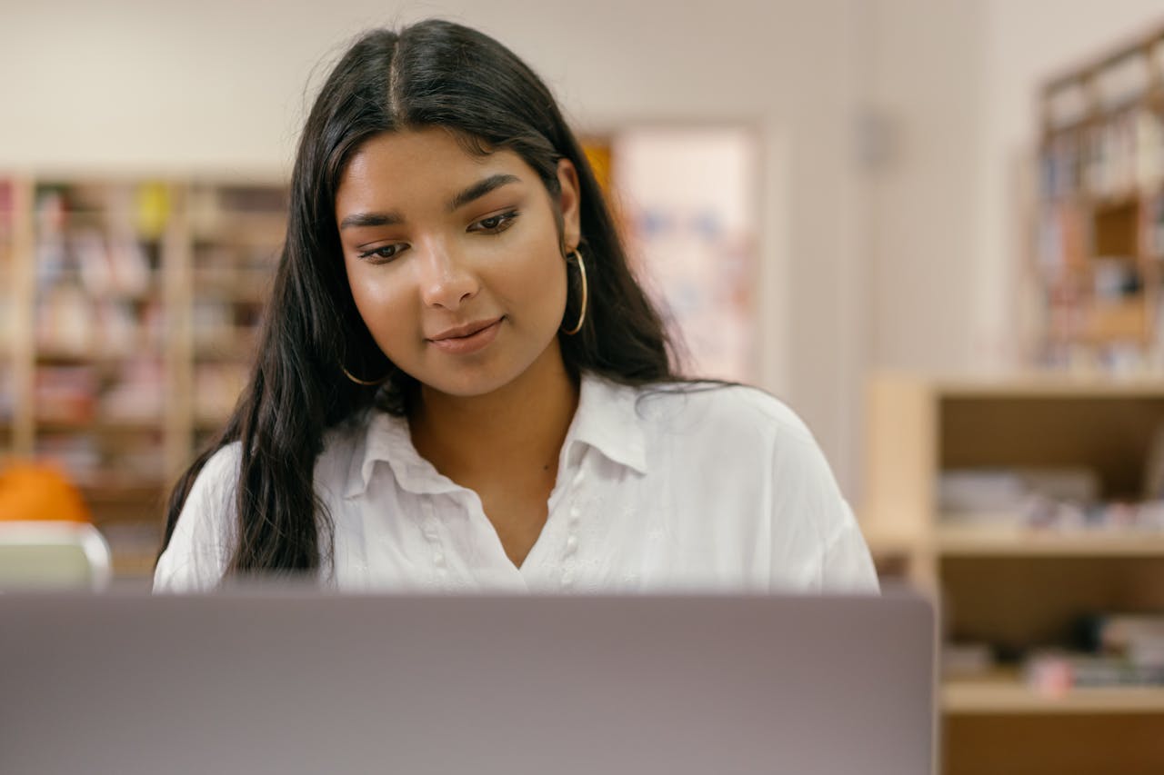 Student filling out college application information. Photo by Mikhail Nilov on Pexels.com.