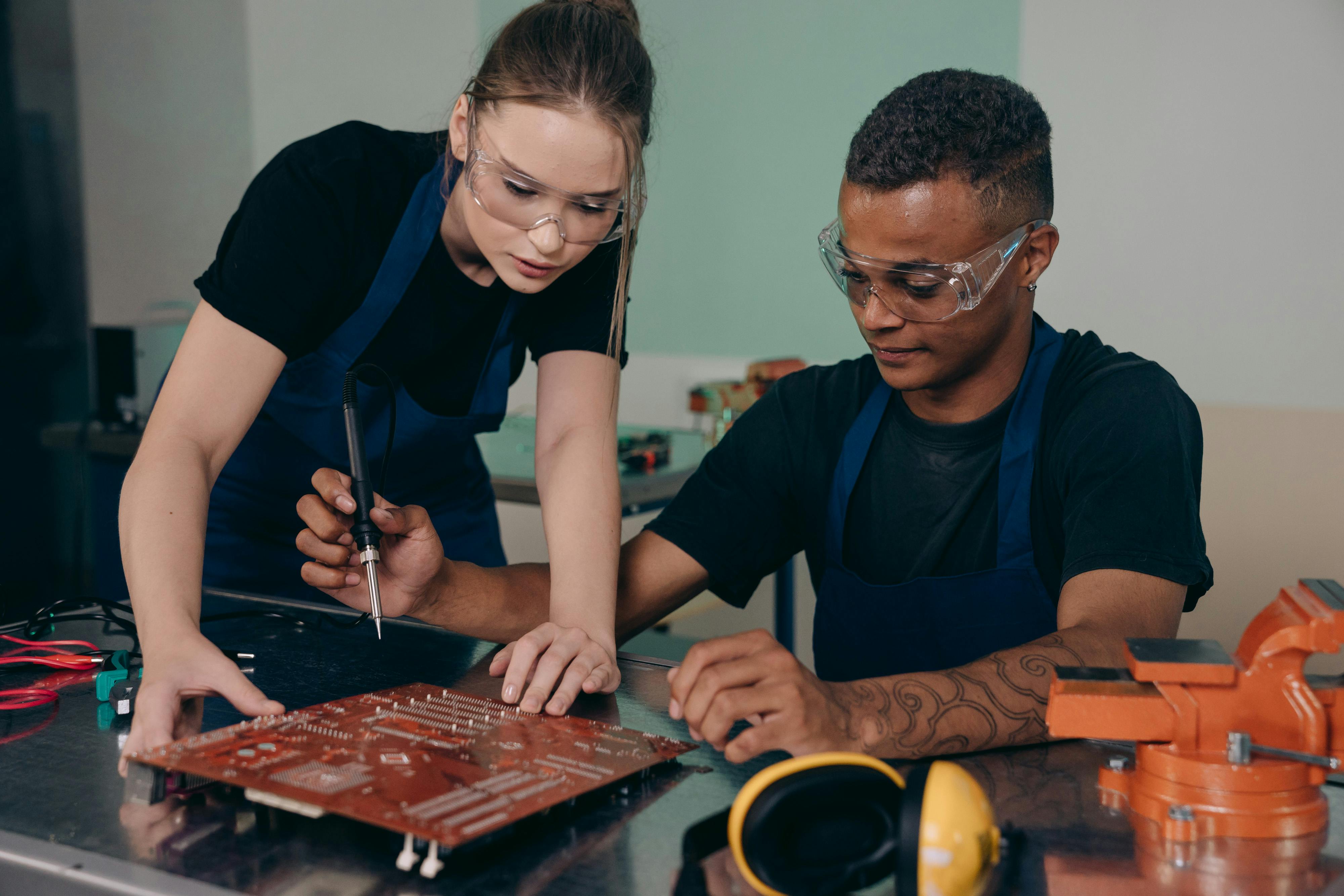 Students putting together a motherboard as a team. Photo by Mikhail Nilov on Pexels.com.