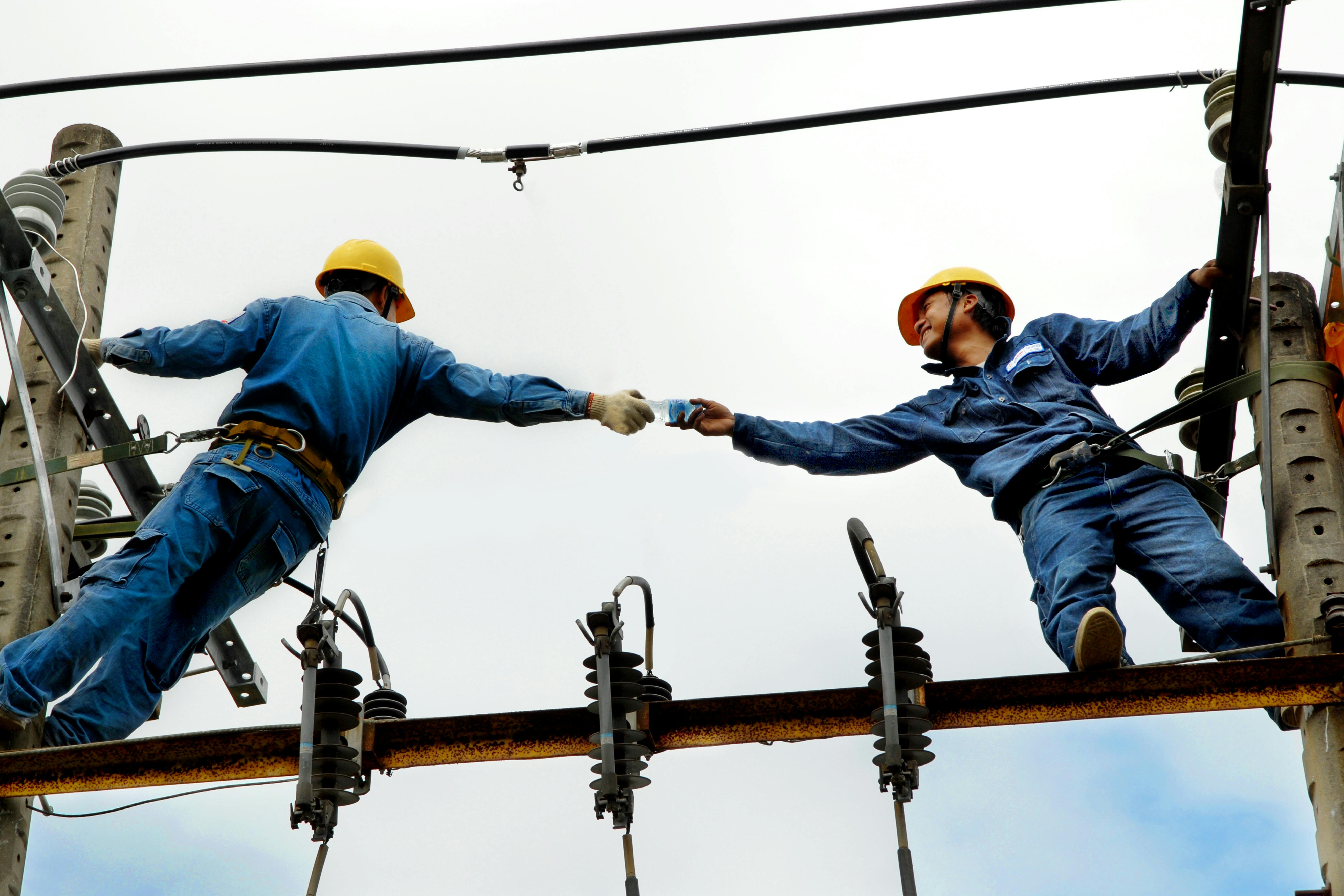 Electricians passing water to each other. Photo by RDNE Stock Project on Pexels.com.